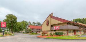 a building with a sign on the side of a road at Red Roof Inn Memphis East in Memphis