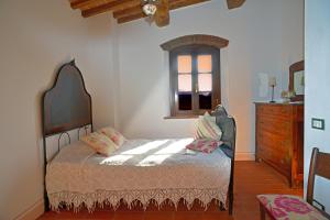 a bedroom with a bed and a dresser at Agriturismo Bioli in Querceto