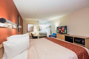 a hotel room with a large bed and a desk at Red Roof Inn Cincinnati - Sharonville in Sharonville