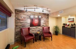 a waiting room with two chairs and a brick wall at Red Roof Inn Detroit Metro Airport - Taylor in Taylor