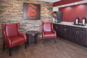 un bar con 2 sillas, mesa y TV en Red Roof Inn Champaign - University, en Champaign