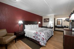 a hotel room with a bed and a chair at Red Roof Inn Champaign - University in Champaign