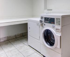 a washer and dryer in a white laundry room at Red Roof Inn Forsyth in Forsyth