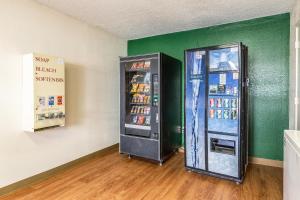 uma máquina de refrigerantes está ao lado de uma parede verde em HomeTowne Studios by Red Roof Atlanta NE - Downtown Norcross em Norcross