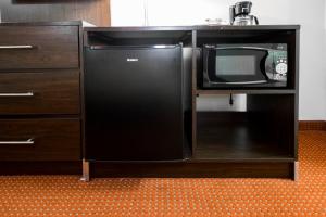 a black refrigerator next to a cabinet with a microwave at Red Roof Inn Columbus Northeast Westerville in Westerville