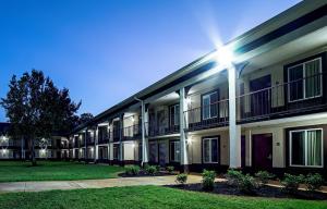 a large apartment building with a lawn in front of it at Red Roof Inn & Suites Greenwood, SC in Greenwood