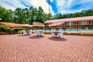 a patio with tables and chairs and umbrellas at Red Roof Inn Hot Springs in Hot Springs