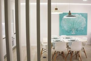 een eetkamer met een tafel en witte stoelen bij Front Sea Apartment in Quarteira