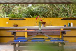 una mesa de madera con sillas azules y un lavabo en Poponé Farm & Lodge en Guápiles