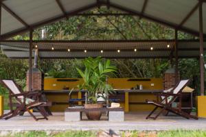 a patio with two chairs and a table in a tent at Poponé Farm & Lodge in Guápiles