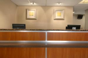 a lobby with a reception counter with two pictures on the wall at Red Roof Inn North Charleston Coliseum in Charleston