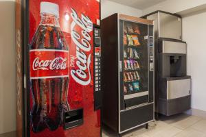 a cocacola bottle vending machine next to a refrigerator at Red Roof Inn Chattanooga - Hamilton Place in Chattanooga