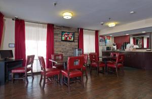 un restaurante con mesas y sillas rojas y un bar en Red Roof Inn Corpus Christi South, en Corpus Christi