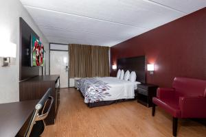 a hotel room with a bed and a red wall at Red Roof Inn Kenly - I-95 in Kenly +14 photos
