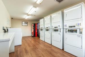a laundry room with white washer and dryers at Studio 51 Extended Stay Hotel in Phoenix