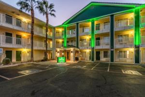 an exterior view of a hotel with green lights at HomeTowne Studios by Red Roof Phoenix - West in Phoenix