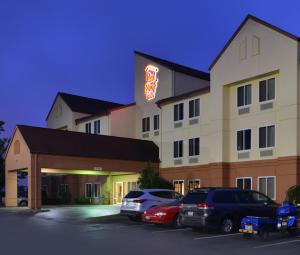 a hotel with cars parked in a parking lot at Red Roof Inn Clyde in Clyde