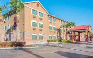 a building with palm trees in front of a street at Red Roof Inn Ocala in Ocala
