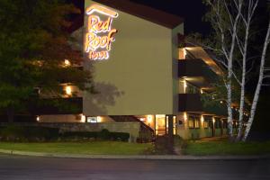 a building with a red roof bar sign at night at Red Roof Inn Syracuse in East Syracuse
