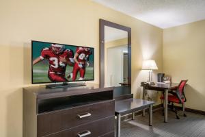 a hotel room with a tv and a desk with a desk at Red Roof Inn Vincennes in Vincennes