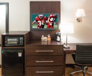 a hotel room with a desk with a tv and a football at Red Roof Inn PLUS+ Washington DC Rockville in Rockville