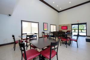 哈蒙德的住宿－Red Roof Inn PLUS+ Hammond，用餐室配有桌子和红色椅子