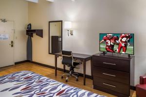 a hotel room with a desk and a tv and a room at Red Roof Inn Richmond, IN in Richmond