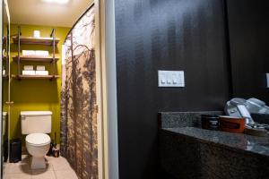 a bathroom with a toilet and a black wall at Campfire Hotel in Bend