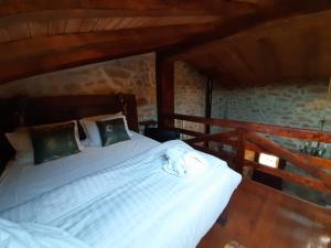 Un dormitorio con una cama blanca en una habitación. en casa de Castelo Mendo, en Castelo Mendo
