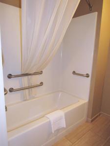 a white bath tub in a bathroom with a curtain at Red Roof Inn Fargo - I-94/Medical Center in Fargo +18 photos