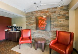 a waiting room with two chairs and a red root sign on a brick wall at Red Roof Inn Hilton Head Island in Hilton Head Island