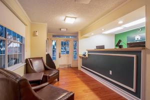 a waiting room with chairs and a flat screen tv at HomeTowne Studios by Red Roof Phoenix - Dunlap Ave in Phoenix