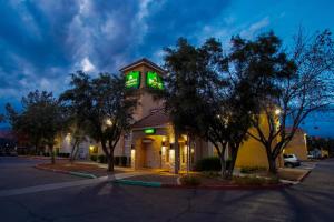 un edificio con una torre de reloj con luces verdes. en HomeTowne Studios by Red Roof Phoenix - Dunlap Ave en Phoenix