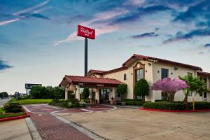 ein Krispy-Kreme-Schild vor einem Hotel in der Unterkunft Red Roof Inn Houston North - FM1960 & I-45 in Houston