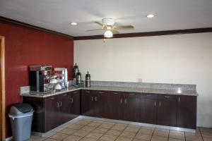 a kitchen with brown cabinets and a ceiling fan at Red Roof Inn Blythe in Blythe