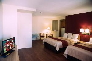 a hotel room with two beds and a flat screen tv at Red Roof Inn Blythe in Blythe +26 photos