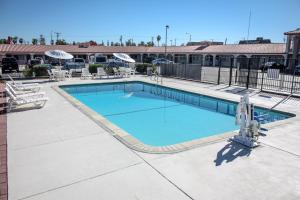 a swimming pool at a resort with tables and chairs at Red Roof Inn Blythe in Blythe
