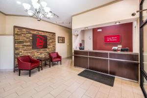 une salle d'attente dans un bureau dentaire avec des chaises rouges et un bureau dans l'établissement Red Roof Inn Clarksville, à Clarksville