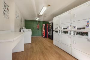 a kitchen with white cabinets and a green wall at HomeTowne Studios by Red Roof Dallas - Mesquite in Mesquite