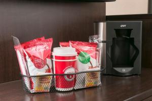 a basket with cups and a coffee maker on a counter at Red Roof Inn PLUS+ Pittsburgh East - Monroeville in Monroeville