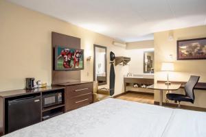 a hotel room with a large bed and a television at Red Roof Inn PLUS+ Baltimore-Washington DC/BWI Airport in Linthicum Heights