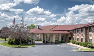 un edificio con una bandera en un aparcamiento en Red Roof Inn & Suites Hermitage, en Hermitage