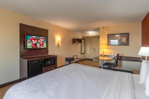 a hotel room with a bed and a television at Red Roof Inn PLUS+ El Paso East in El Paso +26 photos