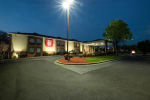 a hotel with a light on a street at night at Red Roof Inn Charlotte - University in Charlotte
