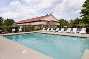 a large swimming pool with chairs and a building at Red Roof Inn Virginia Beach in Virginia Beach