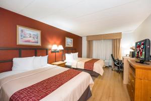 a hotel room with two beds and a flat screen tv at Red Roof Inn & Suites Stafford, VA in Stafford