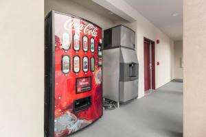 a cocacola vending machine in a room next to a refrigerator at Red Roof Inn Houston - Willowbrook in Houston