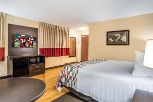 シカゴにあるRed Roof Inn Chicago-Alsipのベッドとテーブルが備わるホテルルームです。