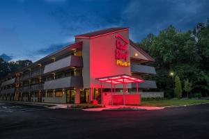 um edifício de uma roulotte vermelha com um sinal vermelho de néon em Red Roof Inn PLUS+ Wilmington - Newark em Christiana