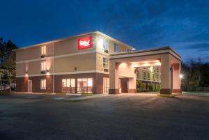 a large building with a red sign on it at Red Roof Inn & Suites Biloxi in Biloxi